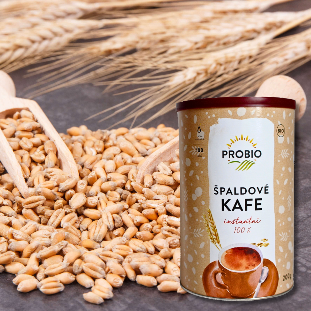 PROBIO Spelt Coffee Instant 100% (200 g) tin standing beside a pile of spelt grains, with wheat ears in the background.
